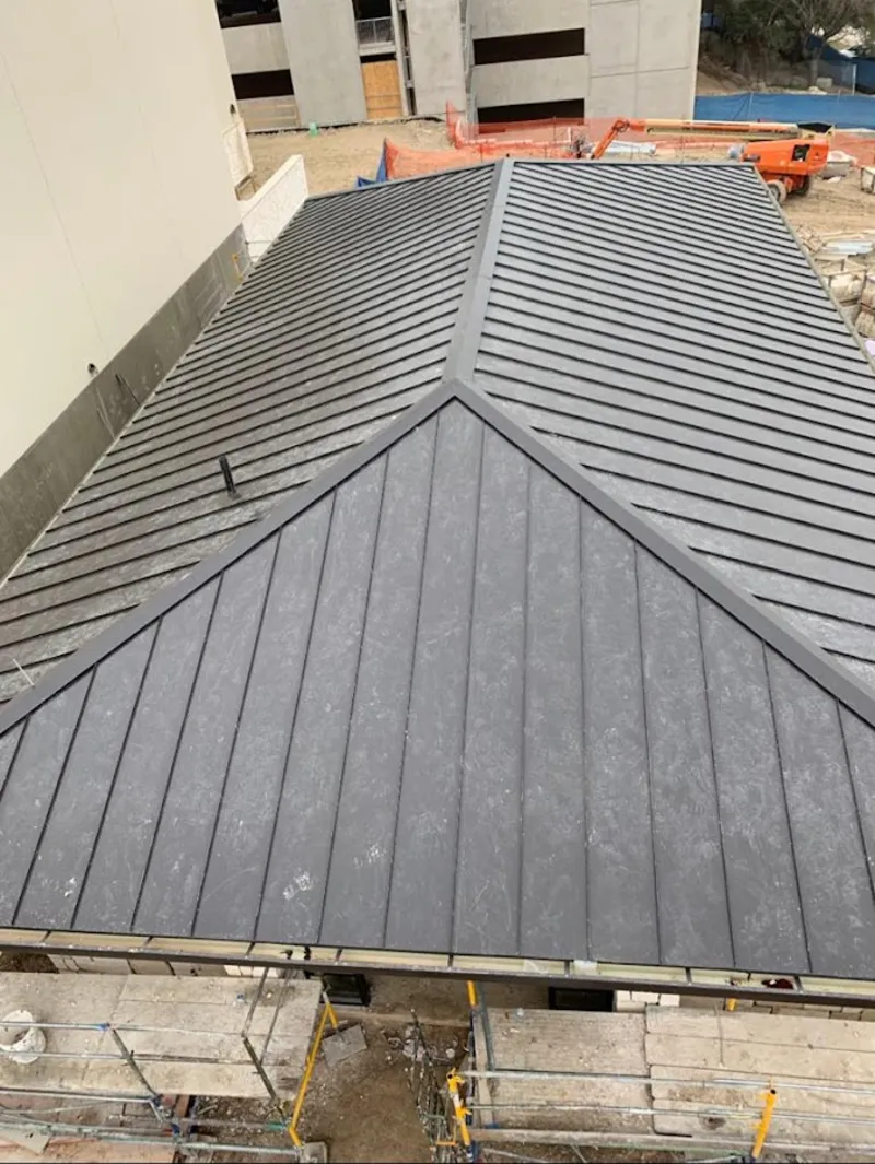 Commercial metal roof construction with crane equipment in Escanaba